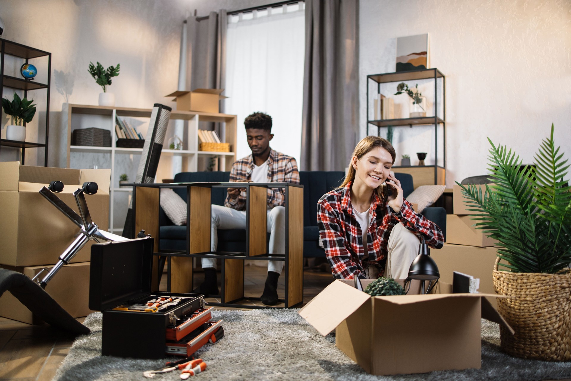 Familia montando muebles y desempacando cajas en casa