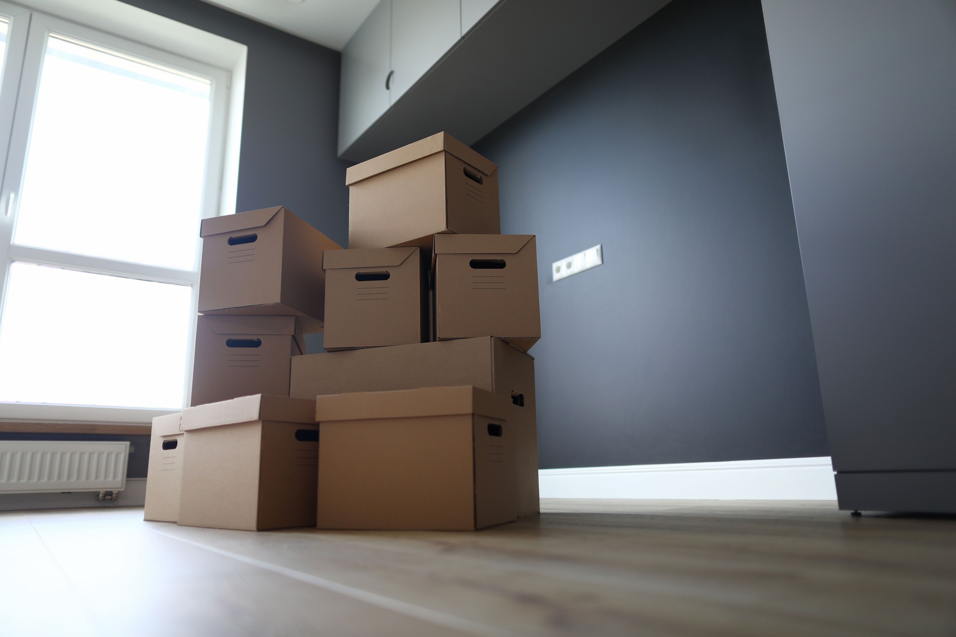 Un montón de cajas de cartón en suelo de madera nuevo primer plano